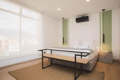 a bedroom with a bed and a large window at NOK Cool 3 BR With Balcony in Laureles Medellin in Medellín