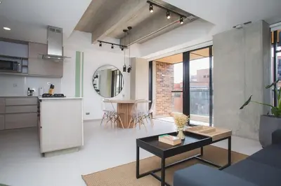 a living room with a table and a kitchen at NOK Cool 3 BR With Balcony in Laureles Medellin in Medellín