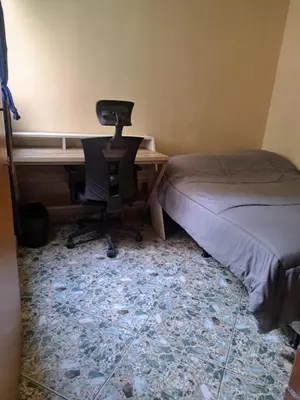 a bedroom with a desk and a chair next to a bed at Comodo apartamento con 2 habitaciones totalmente equipado para estancias largas in Medellín