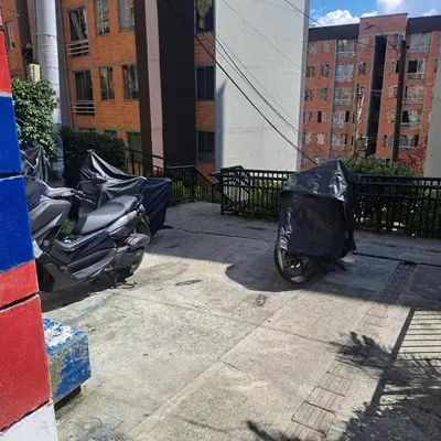 a motorcycle with a cover on it parked on a sidewalk at Comodo apartamento con 2 habitaciones totalmente equipado para estancias largas in Medellín