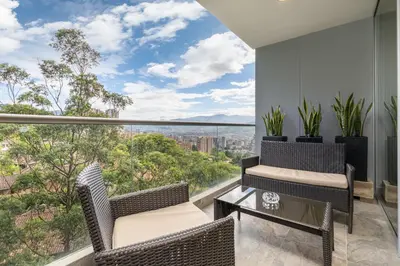 a balcony with chairs and a table with a view at Mountain Views, AC, King Bed, Fast WiFi in Medellín