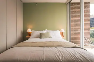 a bedroom with a large bed and a window at Mountain Views, AC, King Bed, Fast WiFi in Medellín
