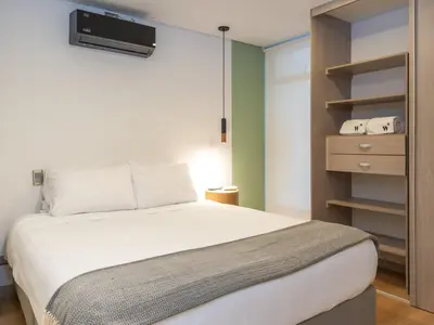 a bedroom with a bed and a tv on the wall at NOK Bright 3BR with terrace in Laureles Medellin in Medellín