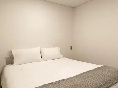 a bed with white sheets and pillows in a room at NOK Bright 3BR with terrace in Laureles Medellin in Medellín