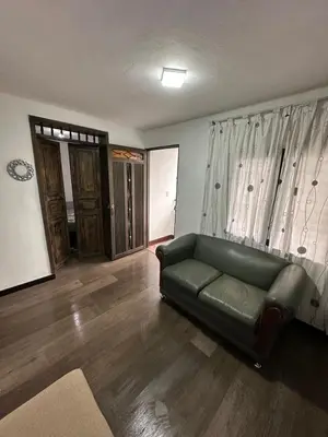 a living room with a green couch and wooden floors at Hermoso apartamento en la milagrosa in Medellín