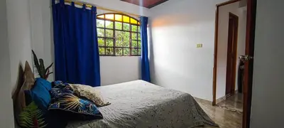 a bedroom with a bed with blue curtains and a window at Alcoba independiente en nuestro hogar santa Elena encantada in Santa Elena