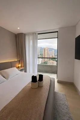 a bedroom with a large bed and a large window at Monaco by Top Location City View in Medellín