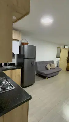 a kitchen with a couch in the middle of a room at Apartamento Cocorna Aventura in Cocorná