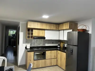 a kitchen with wooden cabinets and a stainless steel refrigerator at Apartamento Cocorna Aventura in Cocorná
