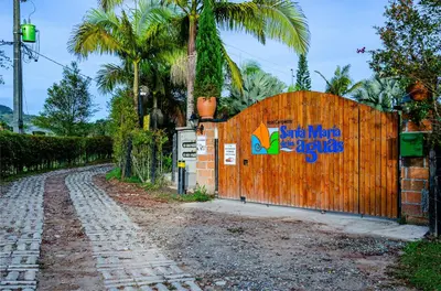 a wooden fence with a sign on it next to a street at Hotel Campestre Santa M de las Aguas in Guatapé