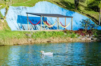 a white duck in the water with a tent at Hotel Campestre Santa M de las Aguas in Guatapé
