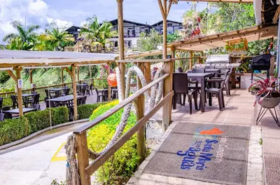 a patio with tables and chairs in a restaurant at Hotel Campestre Santa M de las Aguas in Guatapé