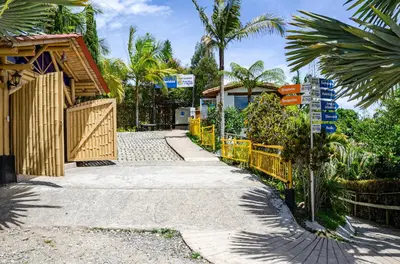 a street with a yellow fence and palm trees at Hotel Campestre Santa M de las Aguas in Guatapé