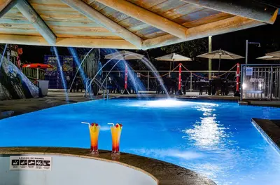 a swimming pool with a water park in the background at Hotel Campestre Santa M de las Aguas in Guatapé