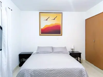a bedroom with a bed and two birds in a picture at Hostal Casa Coliving Laureles Medellin in Medellín
