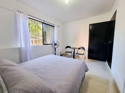 a bedroom with a bed and a window and a table at Hostal Casa Coliving Laureles Medellin in Medellín