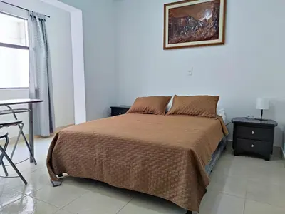 a bedroom with a bed and a table and a picture on the wall at Hostal Casa Coliving Laureles Medellin in Medellín