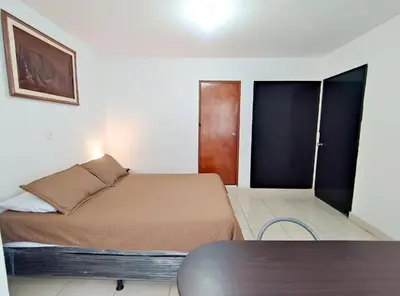 a small bedroom with a bed and a table at Hostal Casa Coliving Laureles Medellin in Medellín