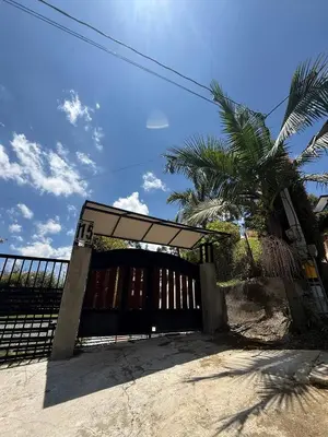 a gate with a fence and a palm tree at Villa with Spectacular Medellin View with Pool and Mini Basket-Futbol Field in Medellín