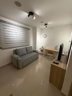 a living room with a couch and a desk with a computer at Confortable y acogedor apartamento en Itagüi in Itagüí