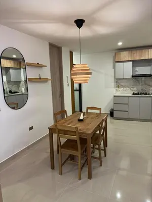 a kitchen and dining room with a wooden table and chairs at Confortable y acogedor apartamento en Itagüi in Itagüí