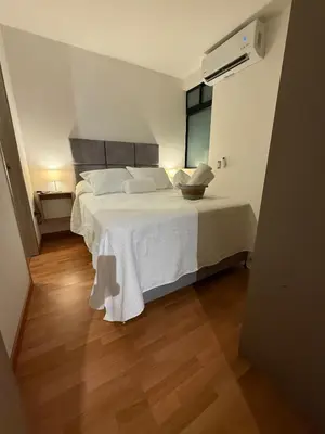 a bedroom with a bed with white sheets and a window at Confortable y acogedor apartamento en Itagüi in Itagüí