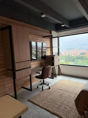 a bedroom with a desk and a chair in front of a window at Loft cerca metro Floresta y Estadio - Aire acondicionado in Medellín