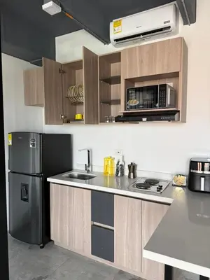 a kitchen with a stainless steel refrigerator and cabinets at Loft cerca metro Floresta y Estadio - Aire acondicionado in Medellín