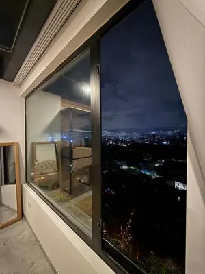 a view of a city skyline seen through a window at Loft cerca metro Floresta y Estadio - Aire acondicionado in Medellín