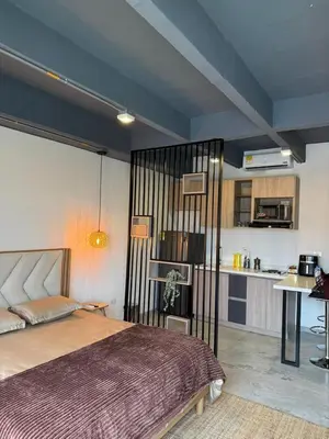 a bedroom with a bed and a kitchen at Loft cerca metro Floresta y Estadio - Aire acondicionado in Medellín