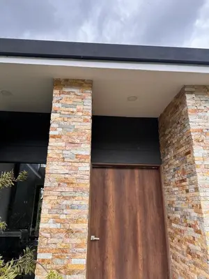 a house with a wooden door and a brick wall at Linda Vista in Rionegro