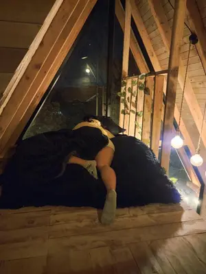 a woman laying on a bed in a attic at Aguapá Glamping in Guarne