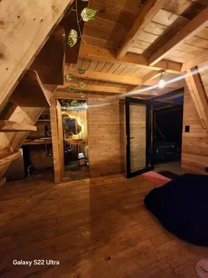 an attic room with wooden walls and wooden floors at Aguapá Glamping in Guarne