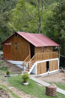 a small wooden building with a red roof at Finca Las Palmas - San Luis in San Luis