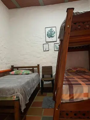 a bedroom with a bunk bed and a chair at Hotel Casa Campestre in Jardin