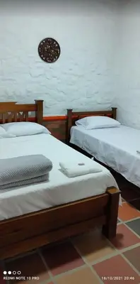 two beds sitting next to each other in a room at Hotel Casa Campestre in Jardin