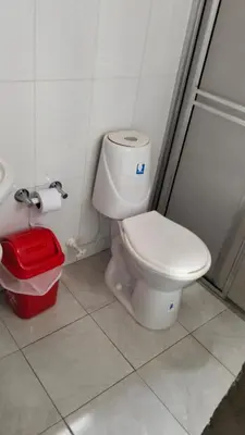 a bathroom with a toilet and a red trash can at Centro Turístico Paraíso del Nare in Alejandría