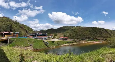 a river with houses on the side of a mountain at Centro Turístico Paraíso del Nare in Alejandría