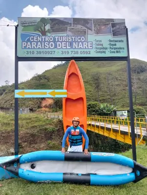 a man is sitting in a kayak in front of a sign at Centro Turístico Paraíso del Nare in Alejandría