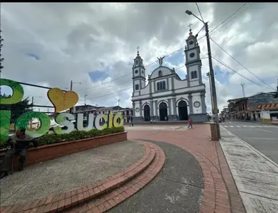 a large white building with a clock tower on a street at Apartamento clásico Riosucio in Ruiosucio