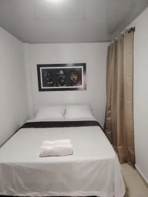a white bed with a towel on it in a room at Apartaestudio Amoblado Chinchina Caldas in Chinchiná