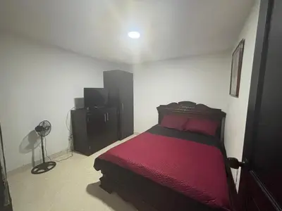 a bedroom with a red bed and a dresser at Hospedaje Doña Blanca 3 in Envigado