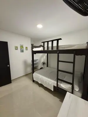 two bunk beds in a room with a table at Comfortable House in Mariquita