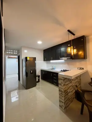 a kitchen with black cabinets and a black refrigerator at Comfortable House in Mariquita