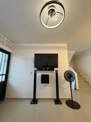 a room with a tv and a fan and stairs at Comfortable House in Mariquita