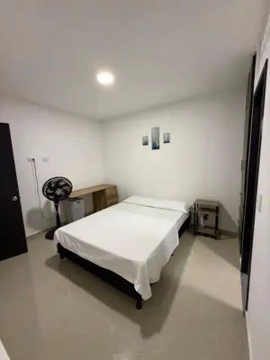 a bedroom with a bed in a white room at Comfortable House in Mariquita