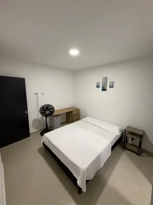 a bedroom with a bed in a white room at Comfortable House in Mariquita