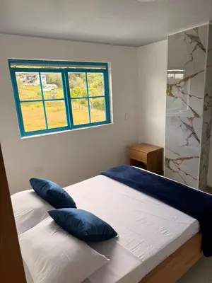 a bedroom with a bed with blue pillows on it at Apartamento céntrico, Guatape, cerca al malecon in Guatapé