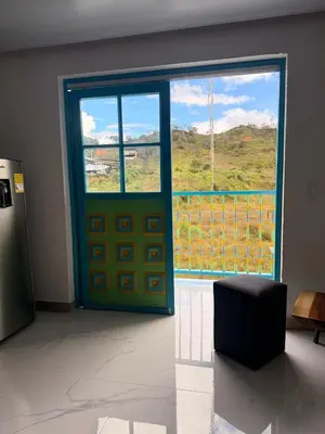 a door in a room with a large window at Apartamento céntrico, Guatape, cerca al malecon in Guatapé