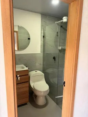 a bathroom with a toilet and a glass shower at Apartamento céntrico, Guatape, cerca al malecon in Guatapé